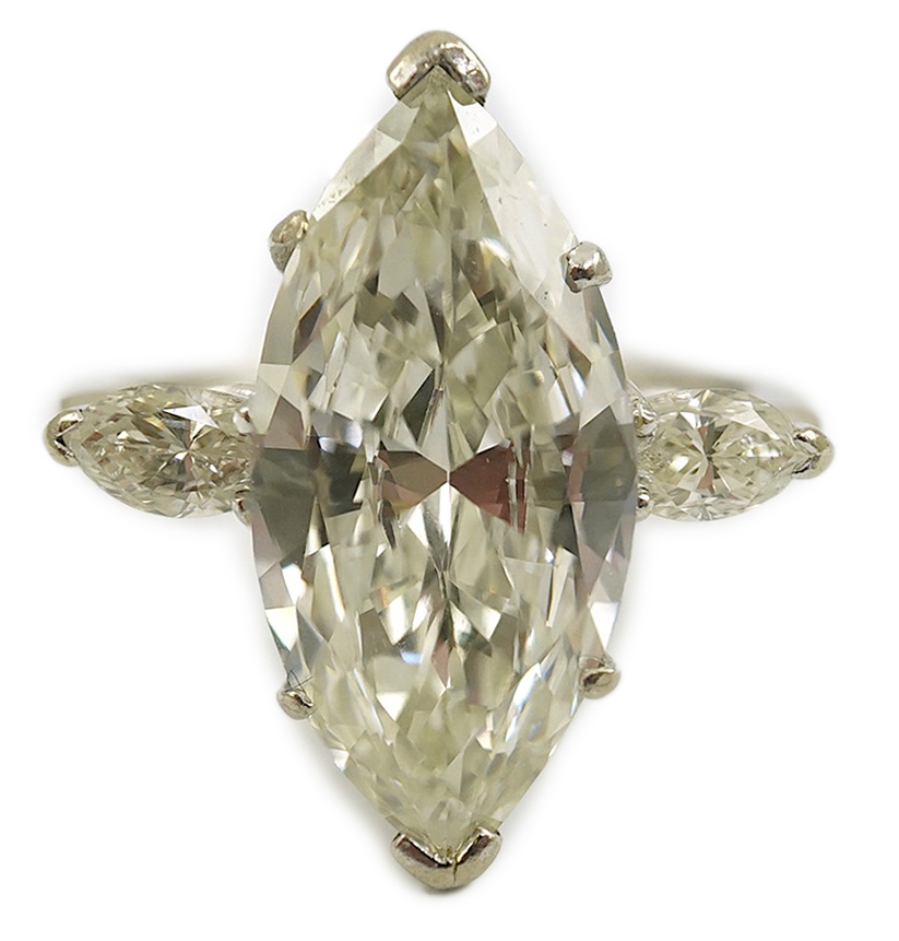 A modern 18ct white gold and single stone marquise cut diamond set ring, with two stone marquise cut diamond set shoulders